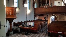 Blick in das Kirchenschiff mit einem Teil des Kamera-, Licht- & Tonsetups. Im Hintergrund ist durch die offene Türe die Regie zu erahnen. (Foto: Nagy/Mit freundlicher Genehmigung)